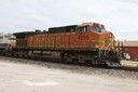 train going through town behind grain elevator